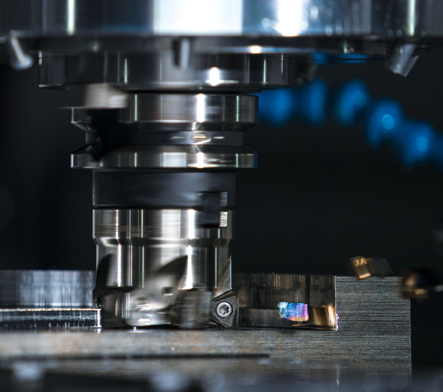 A CNC milling cutter finishing a metal part on a machine bed